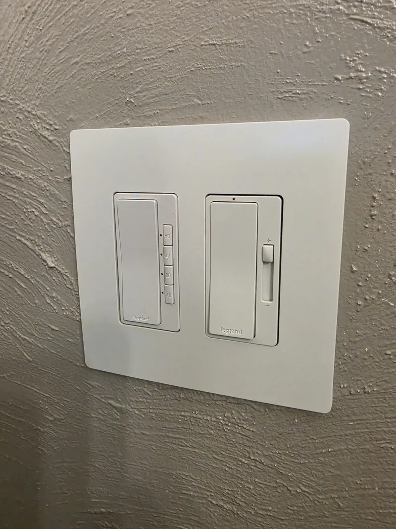 Close-up of a Lutron dimmer and switch installed on a textured wall