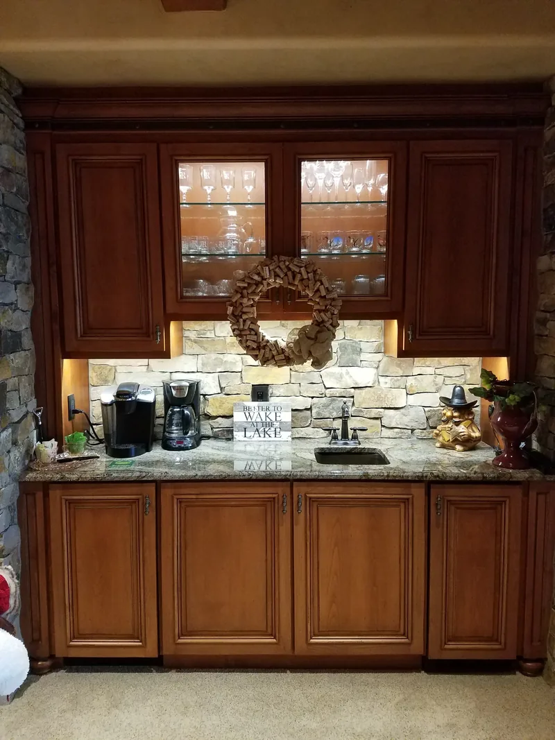 Wet bar with wood cabinets and under-cabinet lighting